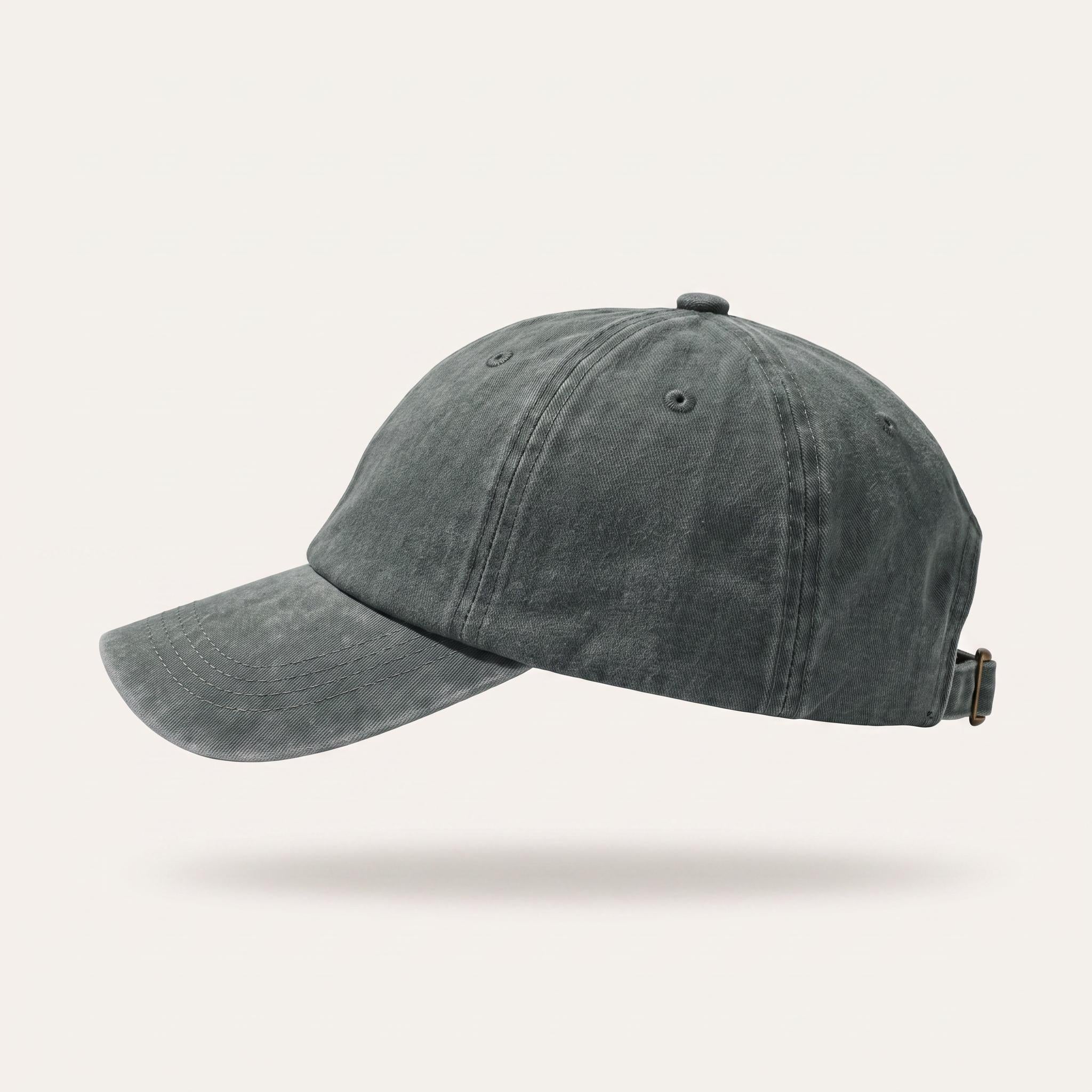 A washed dark gray baseball cap shown from a side profile against a light beige background.