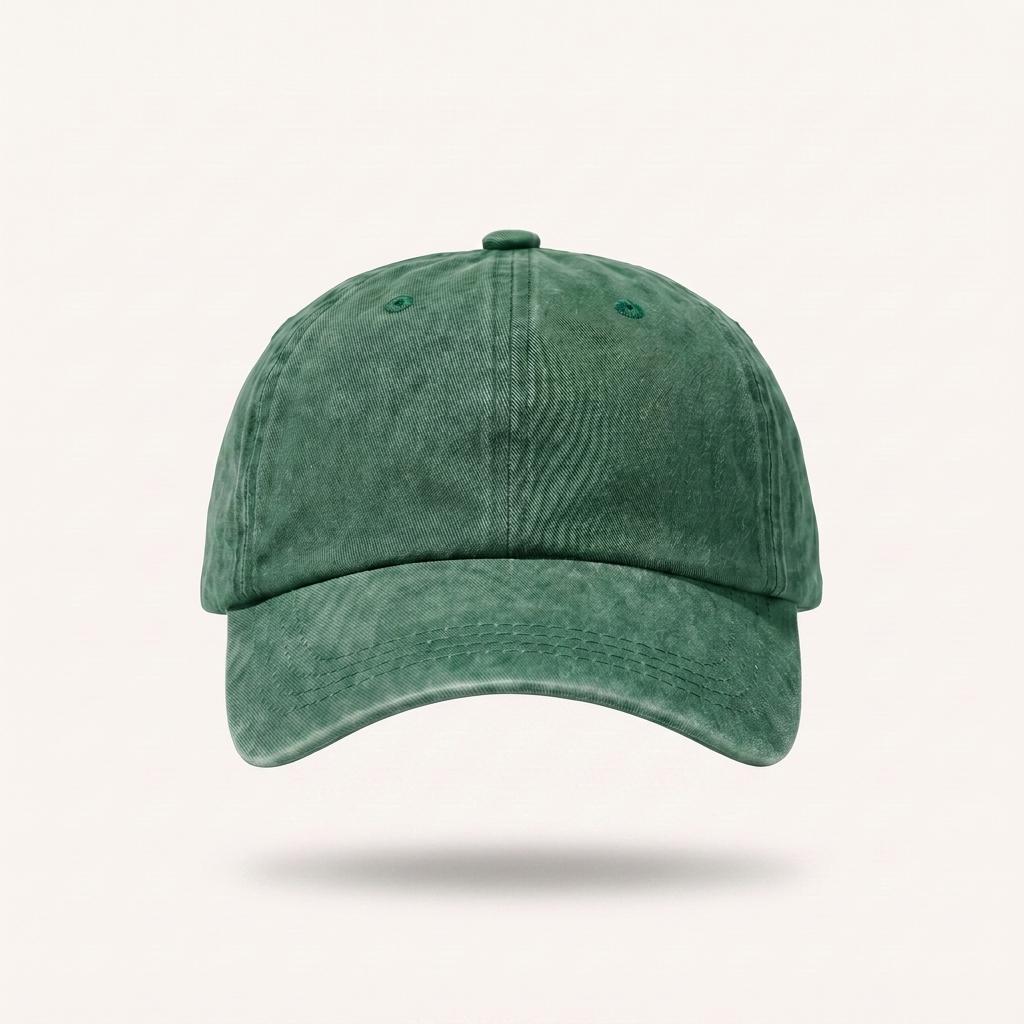 A green washed cotton baseball cap shown from the front on a light beige background with a soft drop shadow underneath.