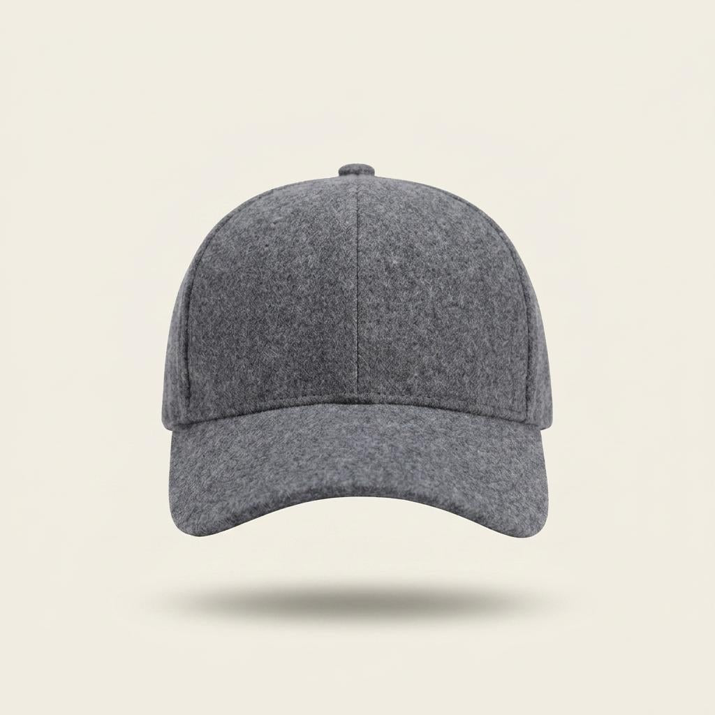 A classic six-panel baseball cap in a heathered dark gray wool or felt-like fabric, shown from a front-facing perspective against a solid light beige background with a soft drop shadow.