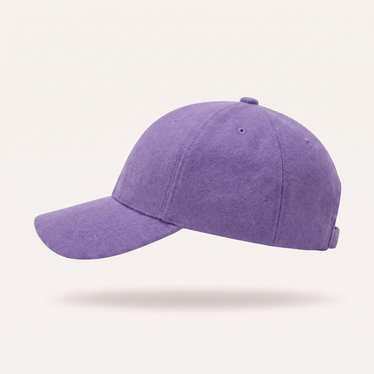 A purple fabric baseball cap shown from a side profile view against a light cream background.