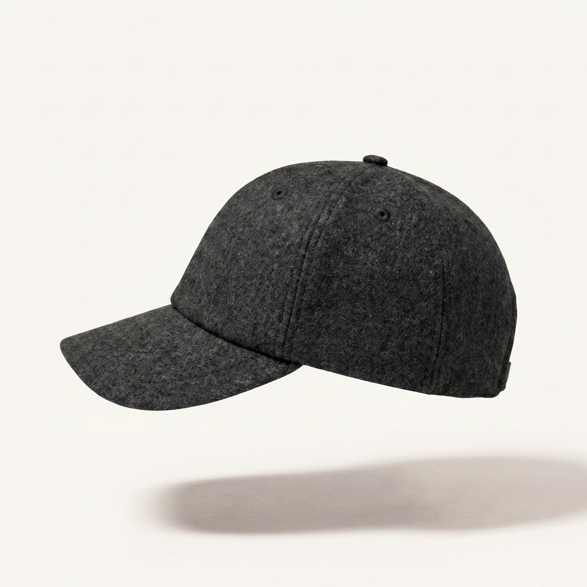 A dark charcoal gray felt baseball cap floating against a clean off-white background with a soft shadow underneath.
