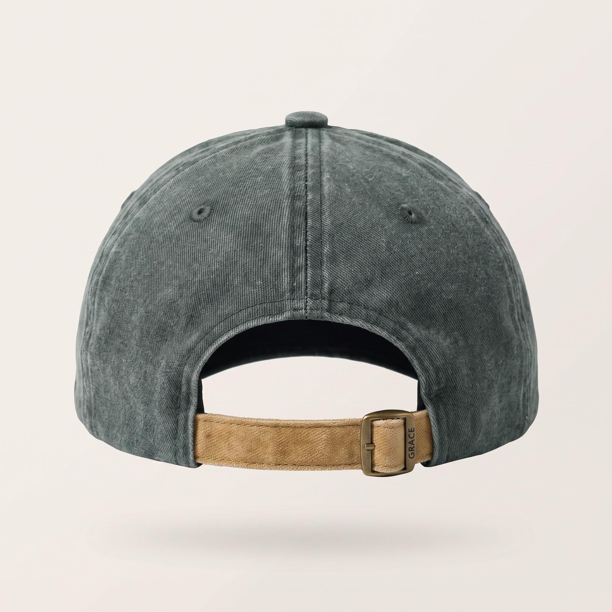 Back view of a washed dark gray baseball cap with a tan adjustable strap and metal buckle, shown on a light beige background.