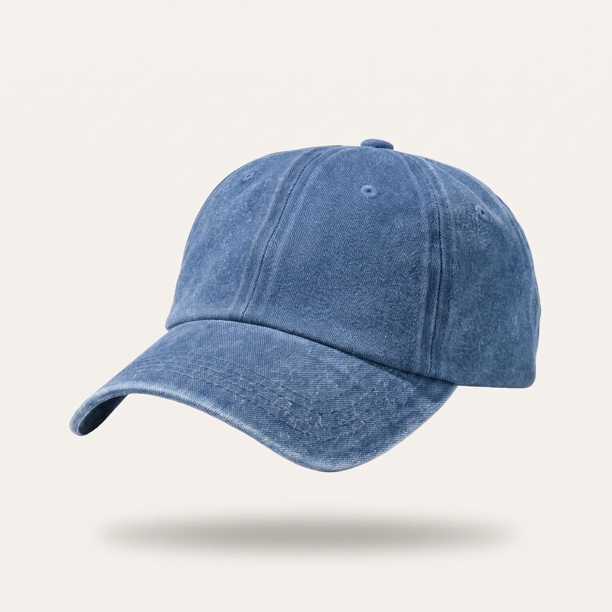 A washed blue cotton baseball cap floating against a light beige background with a soft shadow underneath.