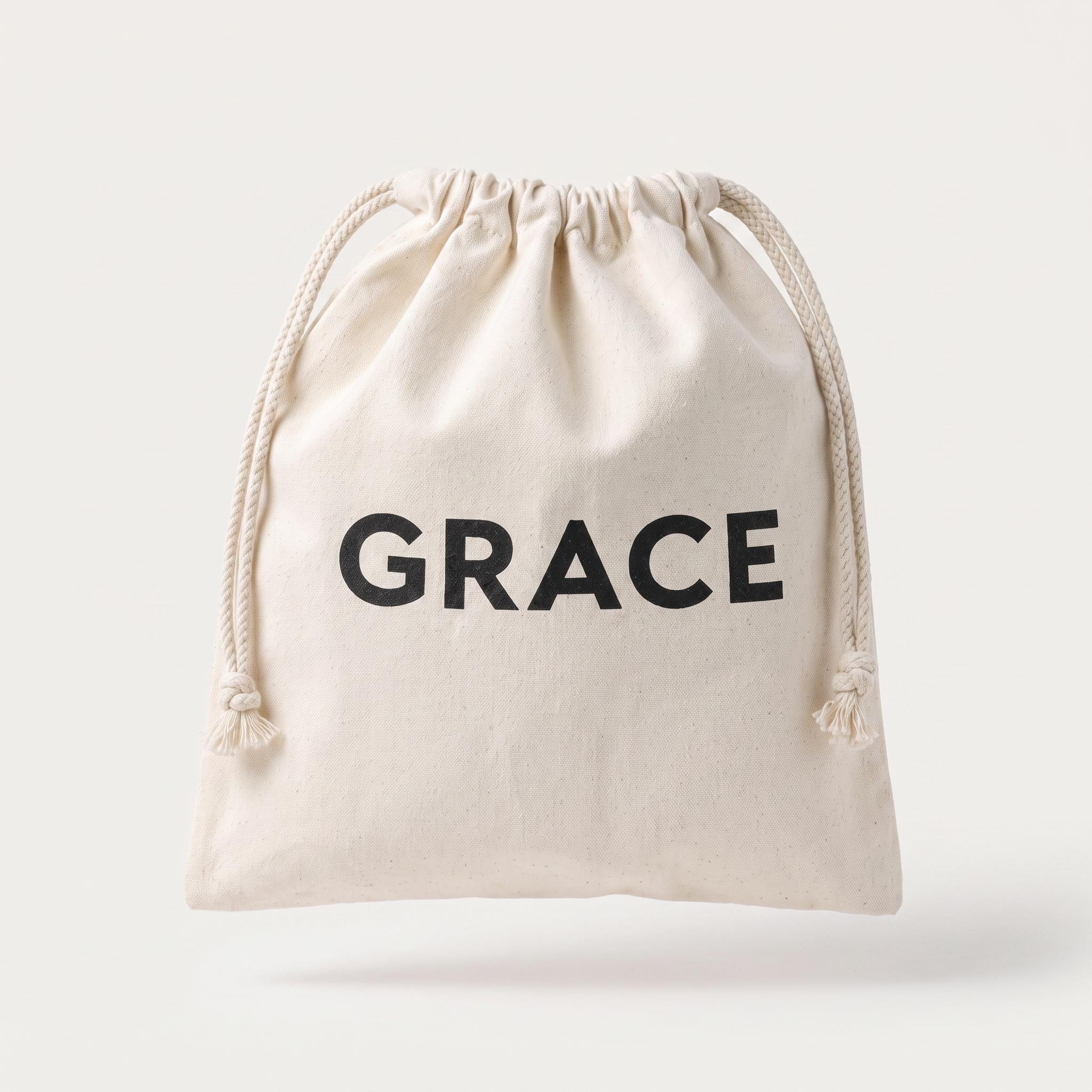 A small off-white canvas drawstring pouch with the word 'GRACE' printed in bold black capital letters on the front, shown against a light gray background.