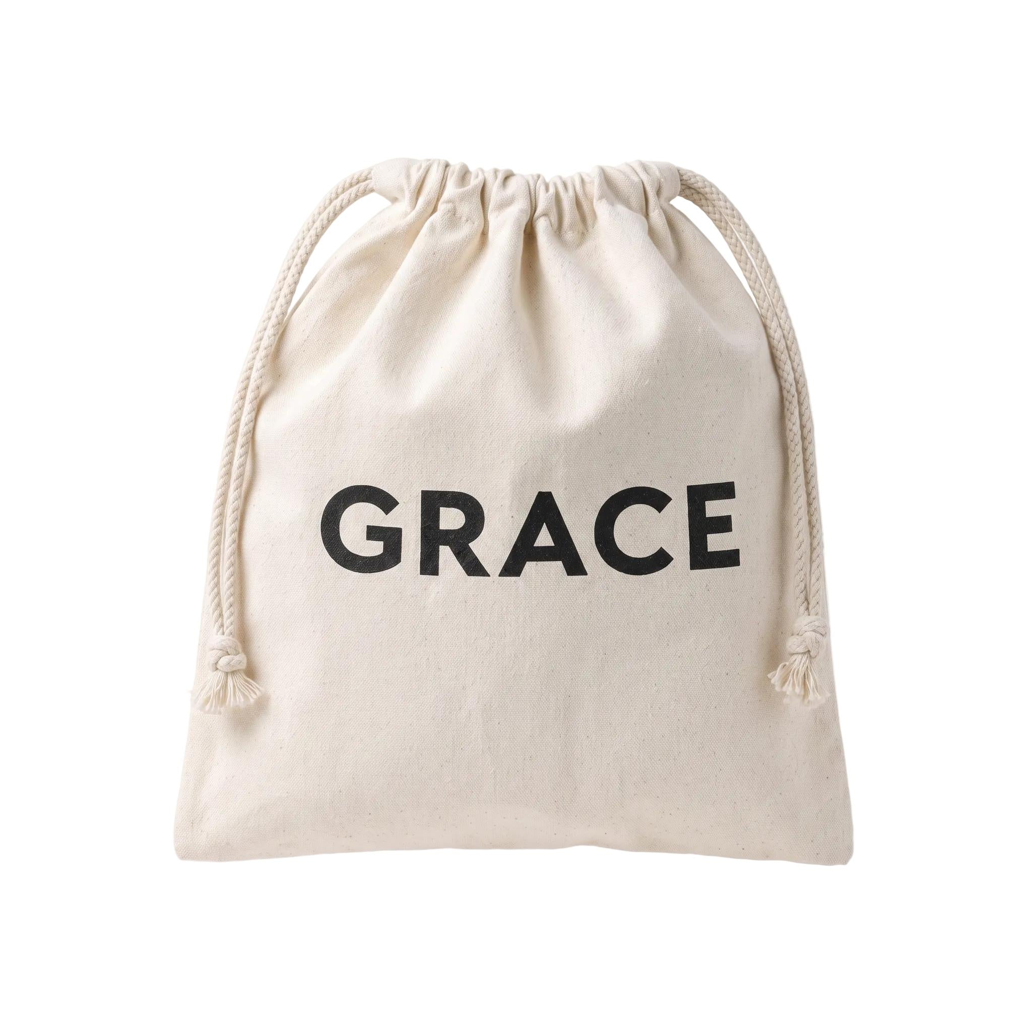 A small off-white canvas drawstring pouch with the word 'GRACE' printed in bold black letters on the front, shown against a plain white background.