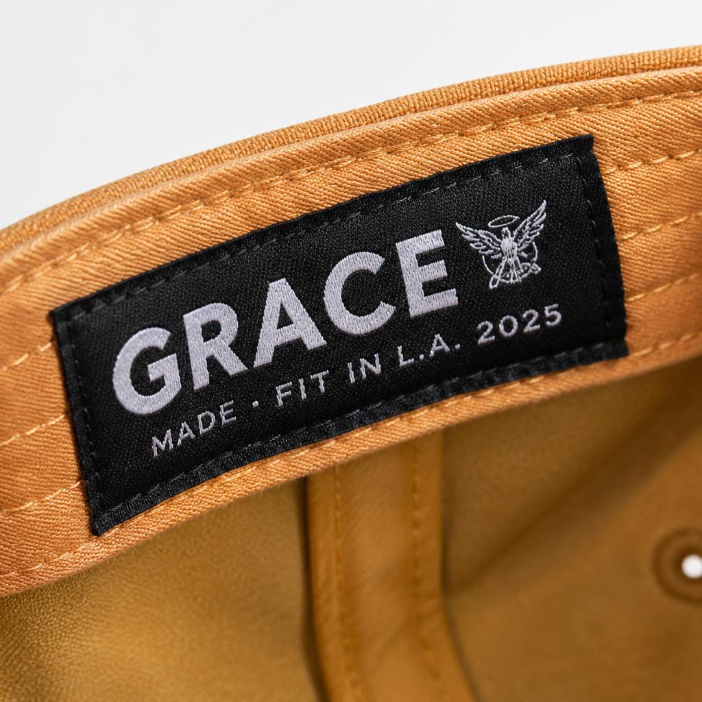 Close-up of a tan fabric interior label patch with a black backing and white text reading GRACE, plus smaller text 'MADE - FIT IN L.A.