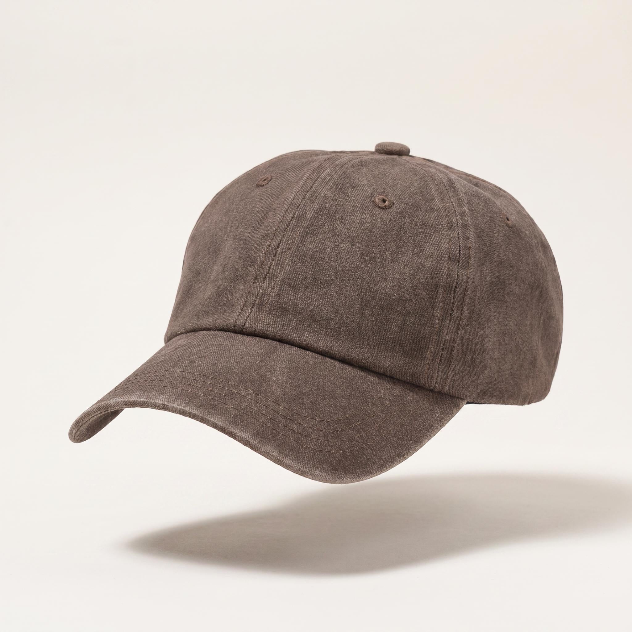 A washed dark brown baseball cap floating against a light beige background with a soft shadow underneath.