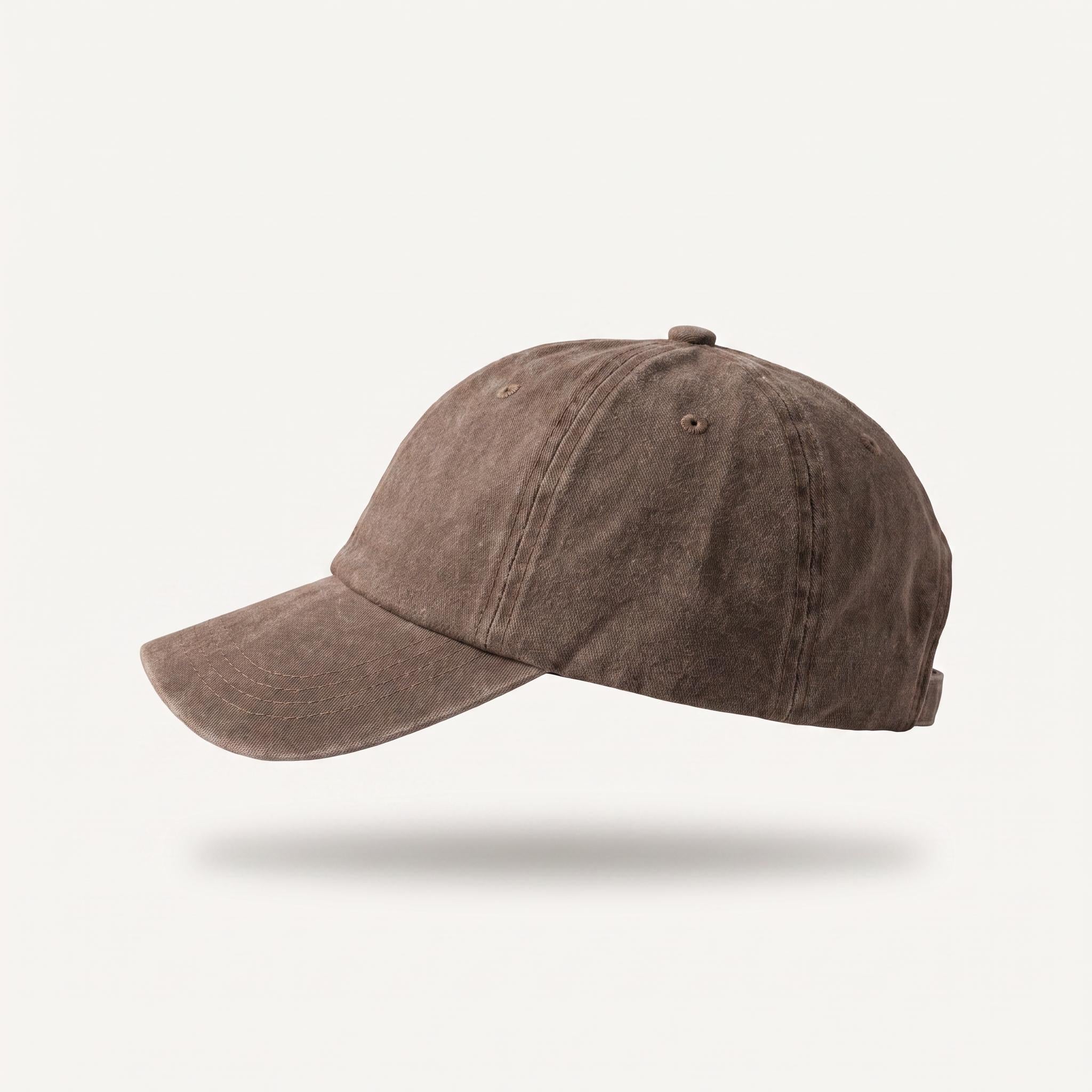 A washed brown baseball cap shown from a side profile view against a light off-white background with a soft drop shadow underneath.