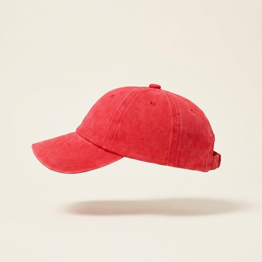 A washed red baseball cap floating against a light beige background with a soft shadow underneath.