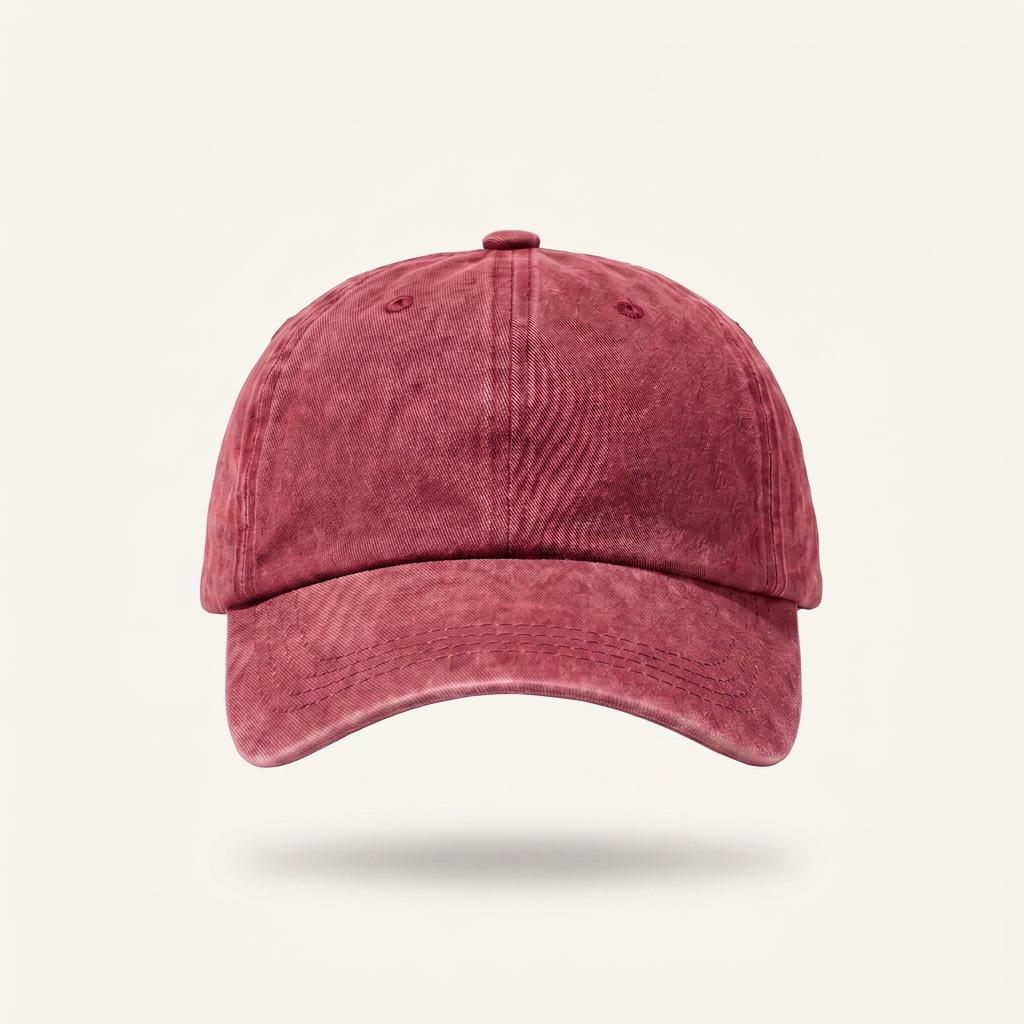 A washed, acid-wash style baseball cap in a dusty rose or muted red color, shown from the front against a light off-white background.