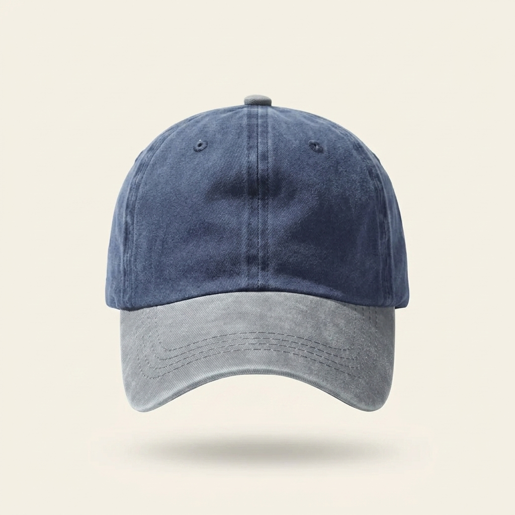 A two-tone baseball cap with a dark blue washed crown and a light gray curved brim, shown against a solid light beige background.