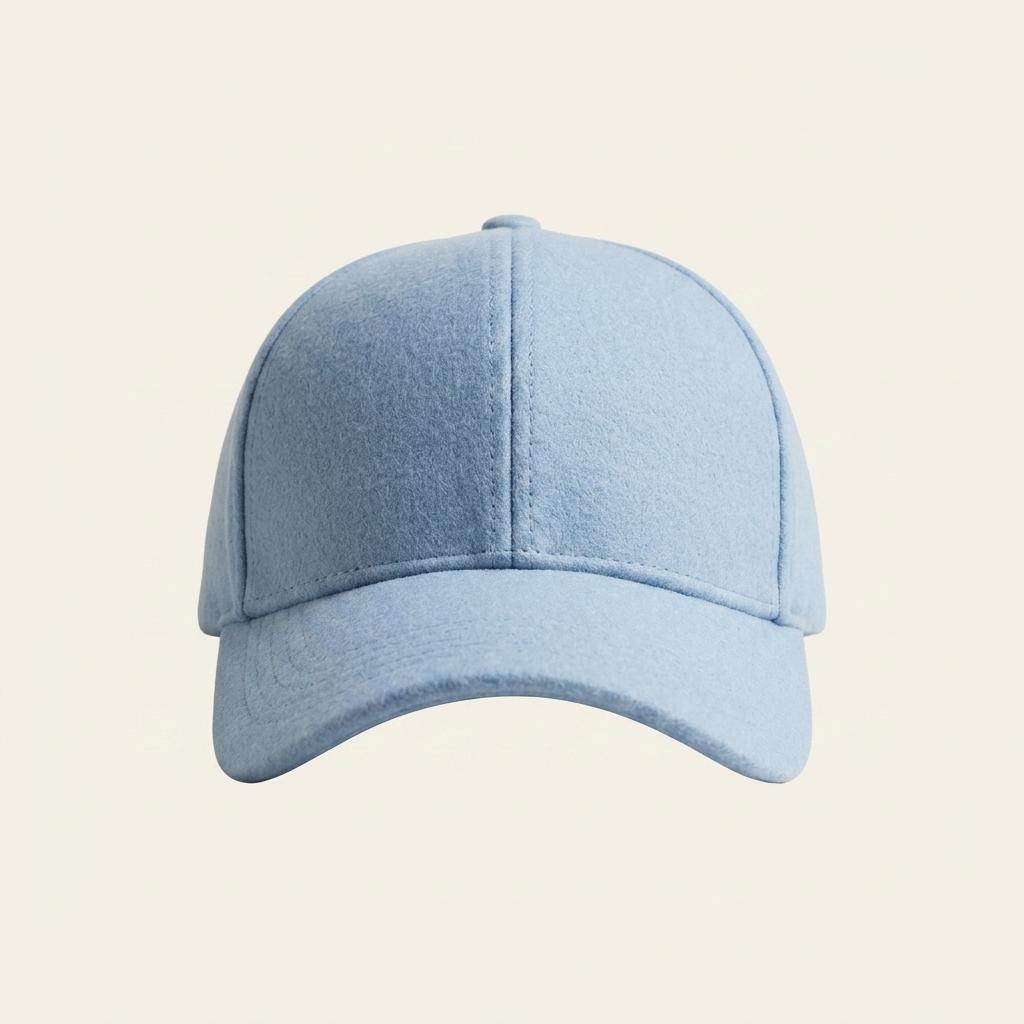 A light blue baseball cap with a curved brim, shown from the front on a solid, warm off-white background.