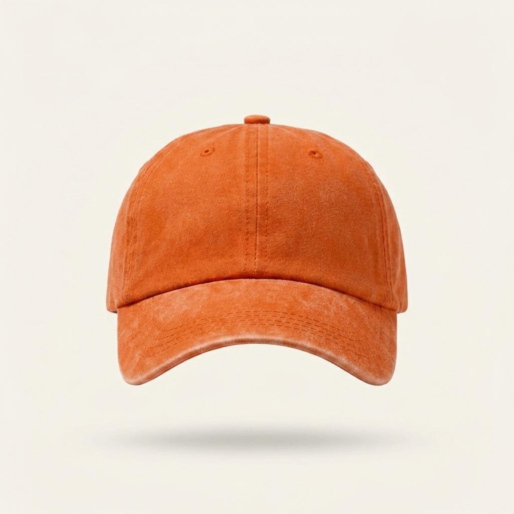 A classic six-panel baseball cap in a washed, distressed orange color, shown floating against a light cream background with a soft shadow underneath.