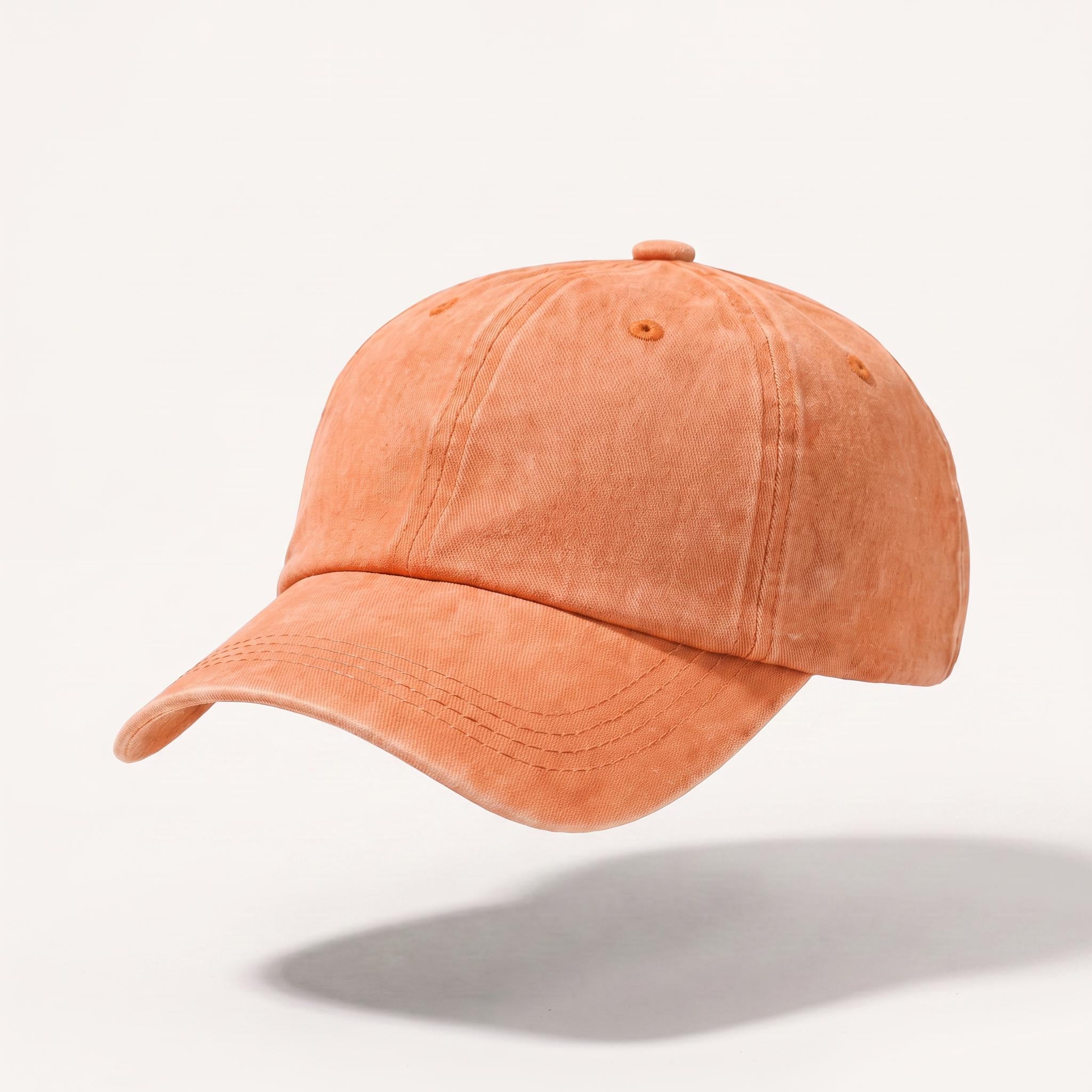 A washed orange baseball cap with a curved brim, floating against a light gray background with a soft shadow underneath.